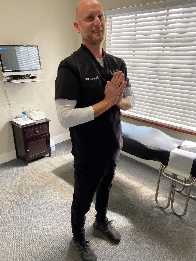 Image of Dr. Daniel Murray: A man is standing up straight, with his hands in a prayer position in the middle of his chest.