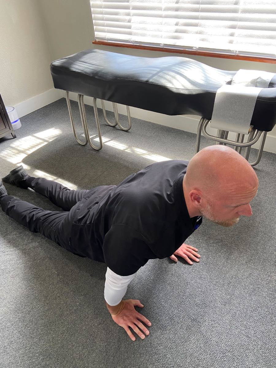 Image of Dr. Daniel Murray: A man with his lower body touching the floor and his upper body stretched up in a cobra position.